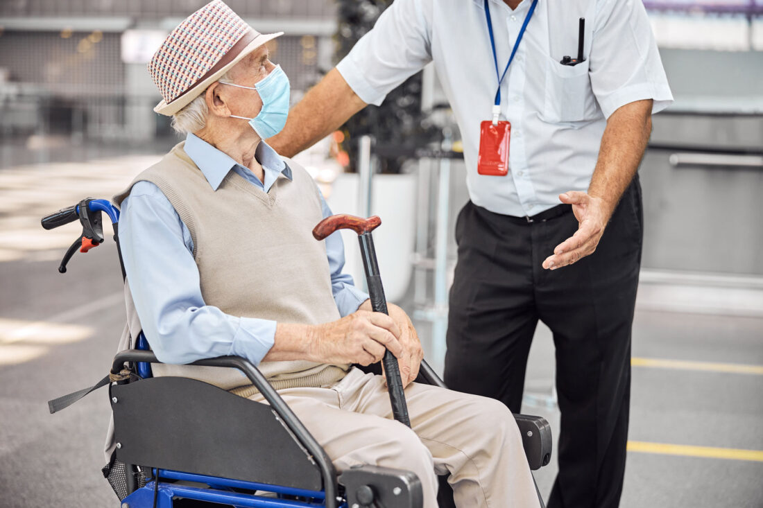 Personne handicapée en fauteuil roulant communiquant avec un employé d'un chauffeur