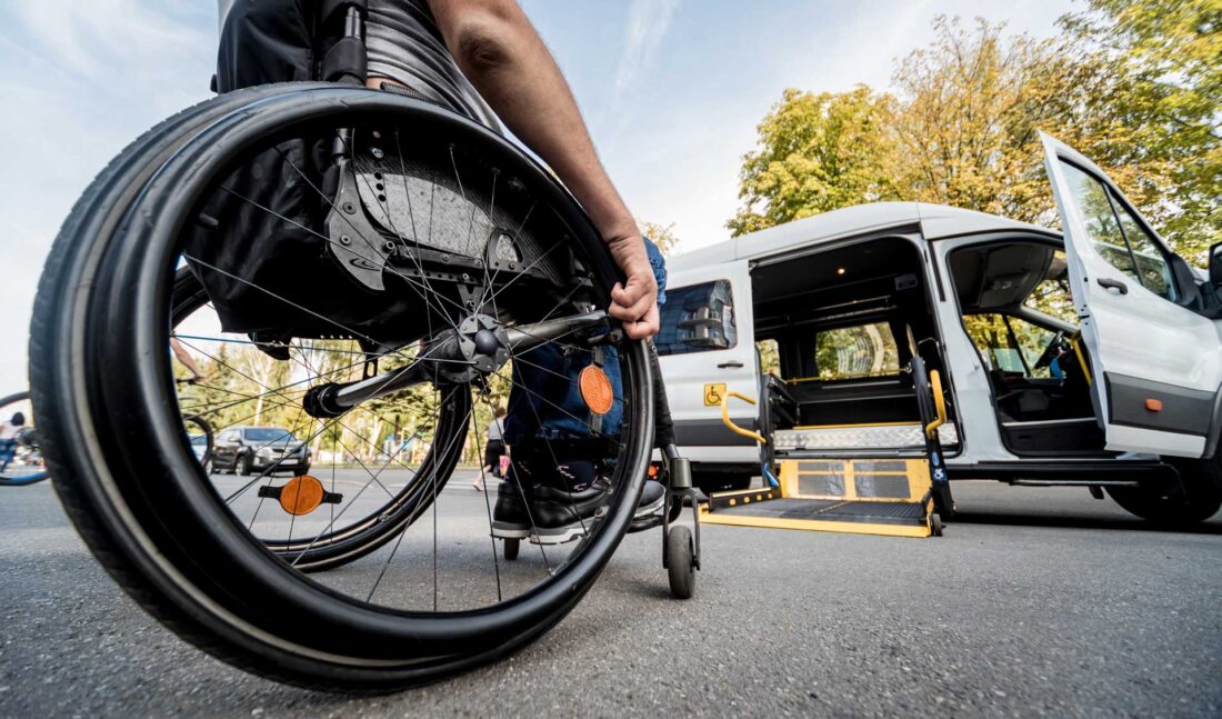 Personne en fauteuil roulant approchant un autobus de transport adapté